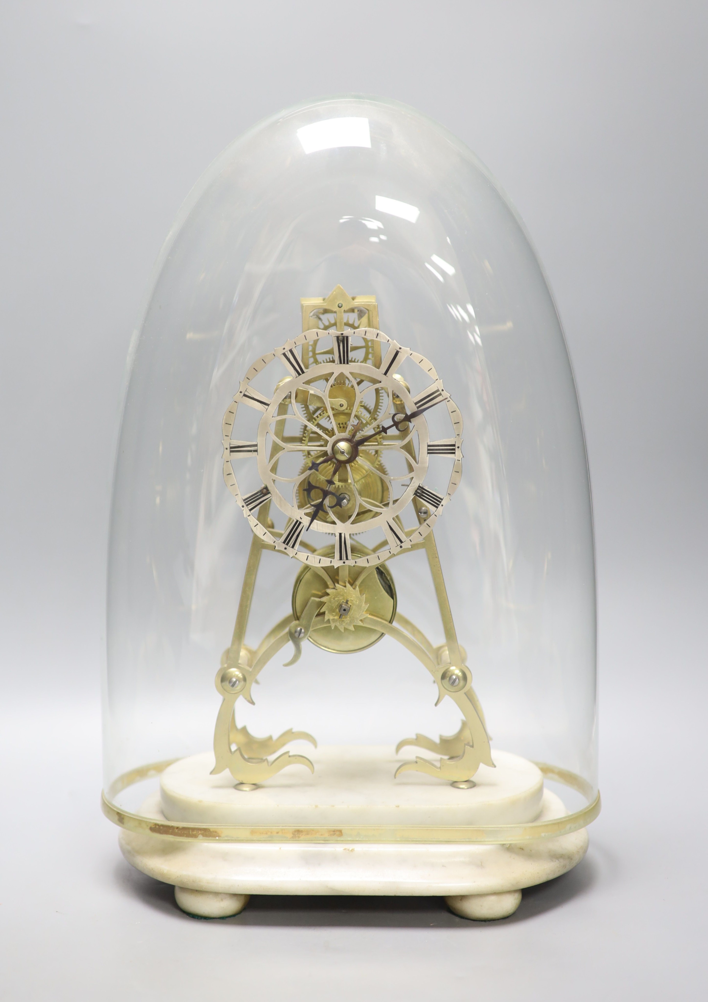 A 19th century brass skeleton clock on marble base. Associated glass dome, total height 44.5 cm